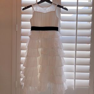 White flower girl dress with black sash and rhinestone headband.